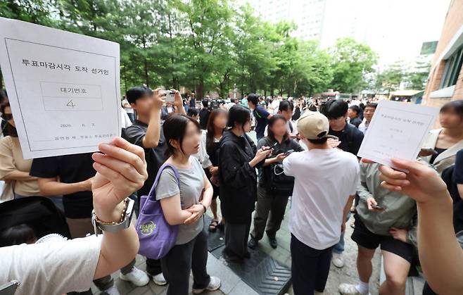 6·3 지방선거 본투표 날인 3일 서울 송파구 잠실2동 6투표소에서 투표용지 부족으로 대기하던 한 유권자가 마감 시간 후 받은 대기 번호표를 들어 보이고 있다. 연합뉴스