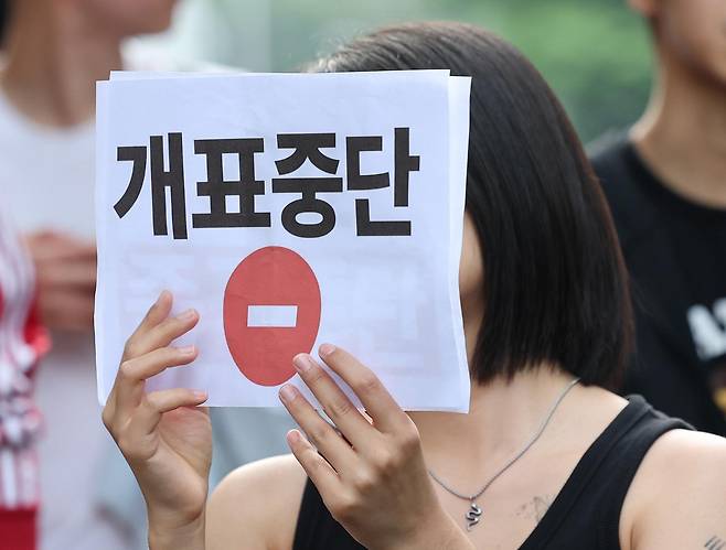 6·3 지방선거 본투표일인 3일 투표용지 부족으로 투표 시간이 오후 10시까지 연장됐던 서울 송파구 잠실7동 제2투표소 앞에서 4일 투표용지 부족 사태에 항의하는 시민이 개표 중단 손팻말을 들고 구호를 외치고 있다. 뉴스1