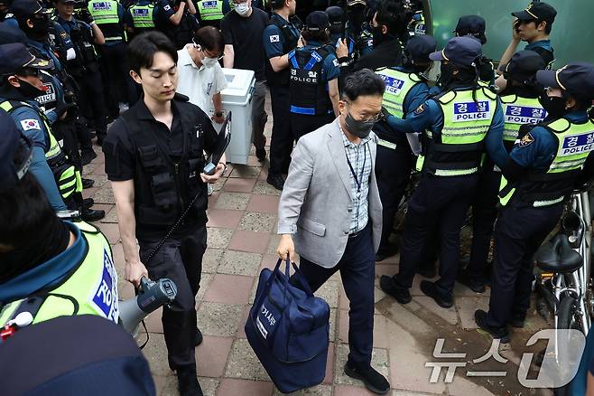 5일 '투표용지 부족' 사태가 발생한 서울 송파구 잠실7동 제2투표소 앞에서 경찰과 서울시선관위 관계자들이 투표함을 이송하고 있다. 2026.6.5 ⓒ 뉴스1 김도우 기자