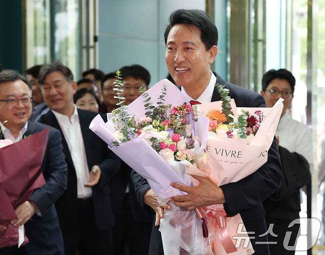 오세훈 서울시장 당선인이 4일 오전 서울시청 로비에서 직원들이 준비해 준 꽃다발을 받고 기뻐하고 있다. (공동취재) 2026.6.4 ⓒ 뉴스1 이호윤 기자