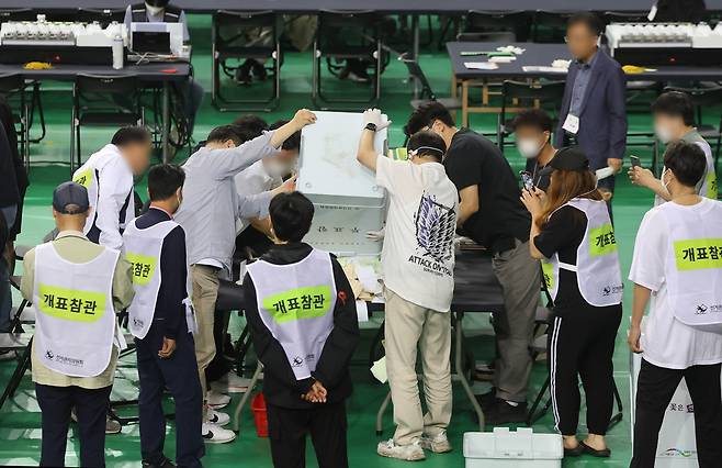서울 송파구 잠실7동 제2투표소에서 이송된 투표함이 5일 개표소인 올림픽공원 핸드볼경기장에 도착해 참관인이 지켜보는 가운데 투표함을 열고 있다. 연합뉴스
