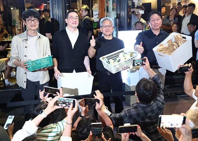 ‘시민들에게 선물’ - ‘시민들에게 선물’ (서울=연합뉴스) 윤동진 기자 = 젠슨 황 엔비디아 최고경영자(CEO)가 5일 서울 마포구 홍대 인근 삼겹살 음식점 ‘형님 저요’에서 최태원 SK그룹 회장, 구광모 LG그룹 회장, 이해진 네이버 의장과 ‘삼소(삼겹살·소주) 회동’을 하며 각종 간식을 시민들에게 나눠주고 있다. 2026.6.5 mon@yna.co.kr (끝)