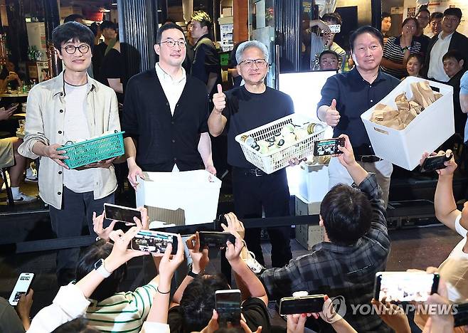 '시민들에게 선물' (서울=연합뉴스) 윤동진 기자 = 젠슨 황 엔비디아 최고경영자(CEO)가 5일 서울 마포구 홍대 인근 삼겹살 음식점 '형님 저요'에서 최태원 SK그룹 회장, 구광모 LG그룹 회장, 이해진 네이버 의장과 '삼소(삼겹살·소주) 회동’을 하며 각종 간식을 시민들에게 나눠주고 있다. 2026.6.5 mon@yna.co.kr