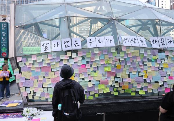 ▲ 강남역 여성살해사건 10주기 행사가 열린 2026년 5월17일 서울 강남역 10번 출구에서 한 시민이 출구에 붙어 있는 문구를 살펴보고 있다. ⓒ연합뉴스