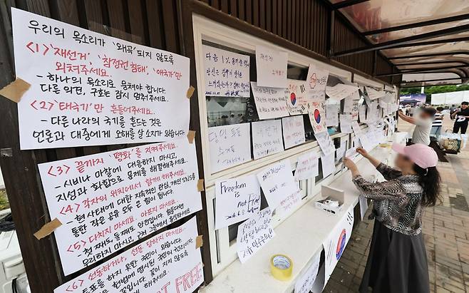 6·3 지방선거 투표지 부족 사태를 규탄하며 재선거를 요구하는 '잠실 개표소 봉쇄 시위'가 계속되고 있는 7일 서울 송파구 올림픽공원 핸드볼경기장 앞 매표소 부스에 재선거를 요구하는 문구 등이 적힌 종이가 붙어있다. 연합뉴스
