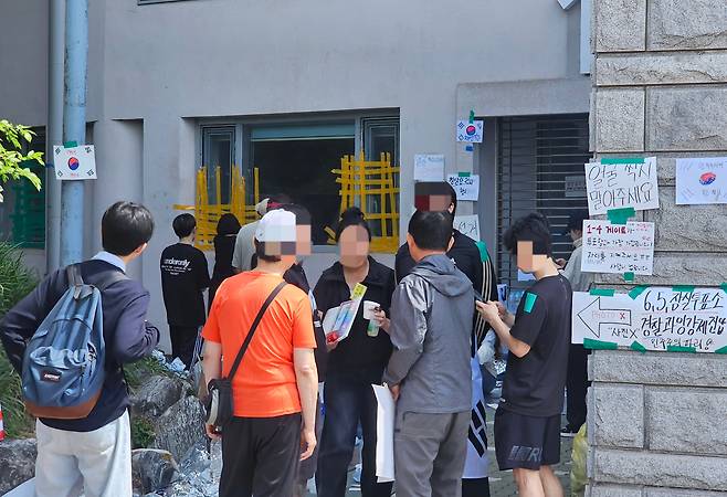 8일 오전 서울 송파구 올림픽공원 핸드볼경기장 창문에 노란 박스테이프를 붙이는 시민과 다른 시민이 말다툼하고 있다./황채영 기자