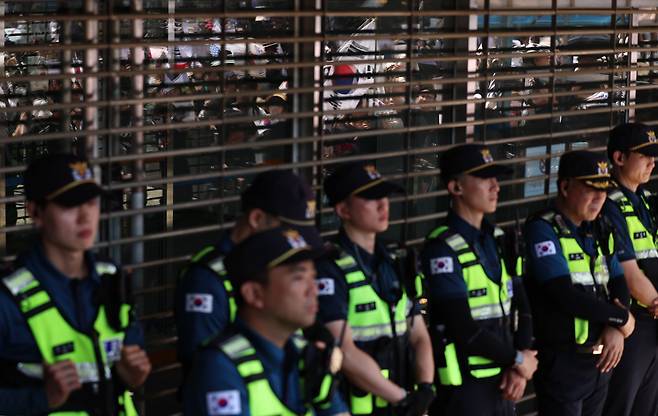 지난 6일 오전 서울 송파구 올림픽공원 핸드볼경기장 개표소를 지키는 경찰 뒤로 6·3 지방선거 투표용지 부족 사태에 반발한 시민들의 모습이 창에 비치고 있다. /뉴스1