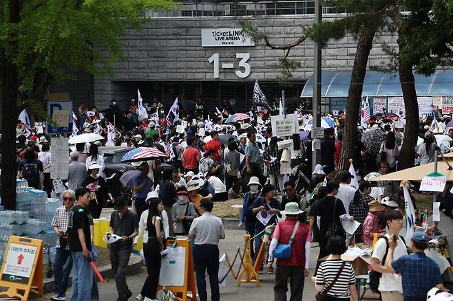 6·3 지방선거 투표용지 부족 사태를 규탄하며 재선거를 요구하는 '잠실 개표소 봉쇄 시위'가 계속되고 있는 8일 서울 송파구 올림픽공원 핸드볼경기장 출입구 앞에서 참가자들이 구호를 외치고 있다. 2026.6.8 연합뉴스