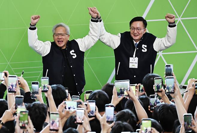 젠슨 황 엔비디아 최고경영자(CEO)가 8일 서울대학교 해동첨단공학관에서 열린 \'\'빌드어클로(Build-a-Claw)\'\' 행사장에서 유홍림 서울대 총장(오른쪽)으로부터 학교 점퍼를 선물받은 뒤 환호하고 있다. 연합뉴스