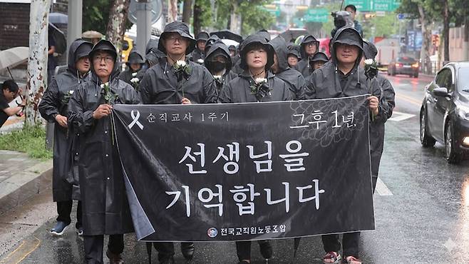 전국교직원노동조합 조합원들과 시민들이 서이초 교사 순직 1주기인 2024년 7월18일 서울 서초구 서이초등학교 앞에서 국화꽃을 들고 행진하고 있다. ⓒ연합뉴스