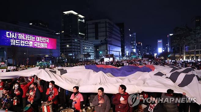 광장의 태극기 (서울=연합뉴스) 황광모 기자 = 2일 밤 서울 종로구 광화문 광장에서 열린 2022 카타르 월드컵 H조 예선 한국과 포르투갈 경기 합동 응원에 나선 붉은악마와 시민들이 대형 태극기를 펼치며 응원을 펼치고 있다. 2022.12.2 hkmpooh@yna.co.kr