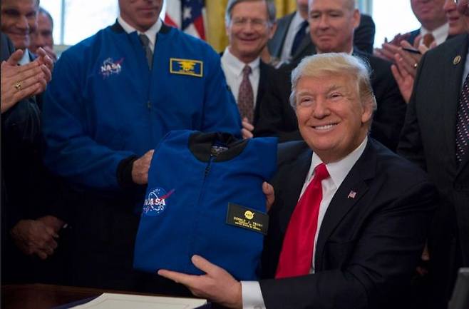 도널드 트럼프 미국 대통령이 지난 2017년 3월 NASA 전환승인법에 서명한 뒤 NASA 비행 재킷을 들어보이고 있다. (사진=백악관) *재판매 및 DB 금지
