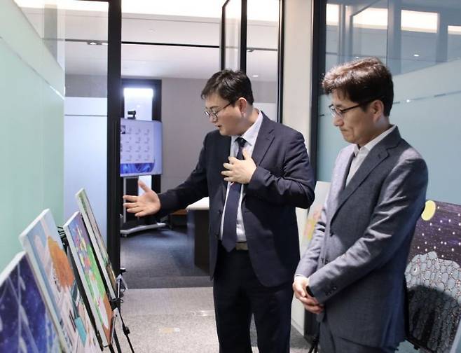 정규태 밀알복지재단 밀알문화예술센터장(왼쪽)이 박형석 마스턴투자운용 대표이사에게 작품 설명을 하고 있다. 마스턴투자운용