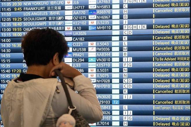 6월3일 일본 도쿄 하네다공항 국제선 터미널에서 한 남성이 항공편 안내 전광판을 바라보고 있다. 이날 열대성 폭풍 '장미(Jangmi)'의 영향으로 항공편이 취소되거나 큰 폭으로 지연됐다. AFP연합뉴스