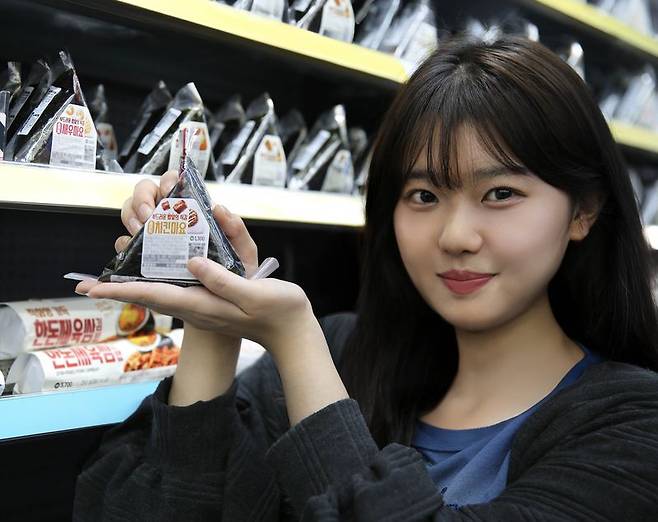 GS25 모델이 새롭게 선보이는 소프트 삼각김밥 '치킨마요' 상품을 들고 포즈를 취하고 있다. GS리테일 제공