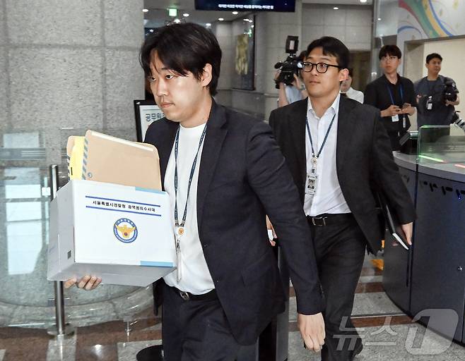 6·3 지방선거 투표지 부족사태 사건을 수사 중인 서울경찰청 광역범죄수사대 관계자가 11일 경기도 과천시 중앙선거관리위원회 선거종합상황실에서 자료를 가지고 안내실로 이동하고 있다. (공동취재) 2026.6.11 ⓒ 뉴스1 김진환 기자