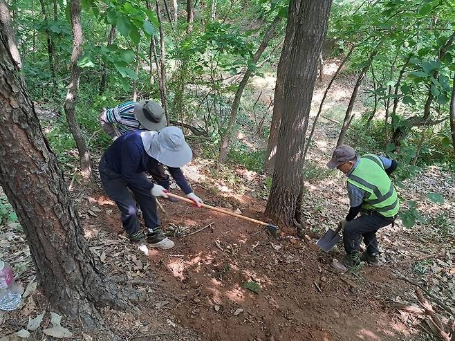 11일 오후 서울 구로구 오류동 옛 공군정보부대 터인 개웅산 일대(천왕동 280-15)에서 인부들이 발굴을 위해 파놓은 땅을 덮고 있다. 고경태 기자