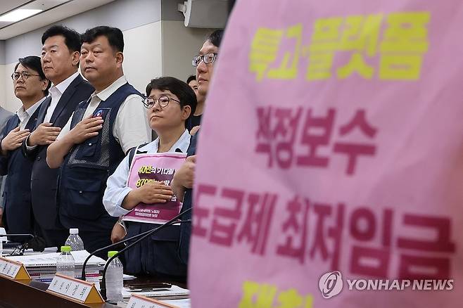 5차 최저임금회의, '도급제 근로자 최저임금 적용' 논의 (세종=연합뉴스) 김주성 기자 = 11일 정부세종청사 최저임금위원회에서 열린 제5차 전원회의에서 근로자위원과 사용자위원들이 국기에 경례하고 있다.
이날 전원회의에서도 도급제 근로자 최저임금 적용 문제를 다시 논의한다.
왼쪽부터 사용자위원인 양옥석 중소기업중앙회 인력정책본부장과 류기정 한국경영자총협회(경총) 전무, 근로자위원인 류기섭 한국노총 사무총장과 민주노총 이미선 부위원장. 2026.6.11 utzza@yna.co.kr