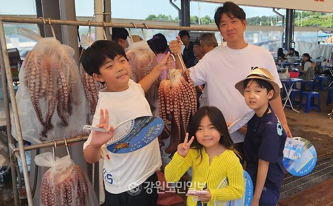 ▲ 13일 최동북단 저도어장에서 갓 잡은 대문어를 한 가족 관광객들이 들어 올리며 즐겁게 기념 사진을 찍고 있다. 김주현 기자