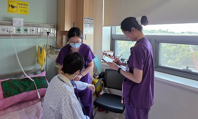 국립암센터의 간호간병통합병동에 입원한 김숙이(가명)씨의 혈압을 재는 간호사들. 허윤희 기자