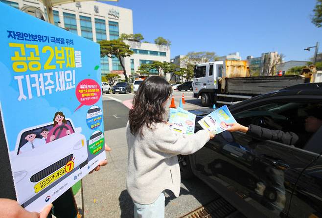 유성구청 직원이 구청 출입 차량에 공공2부제 홍보물을 배부하고 있다. (사진= 대전 유성구)