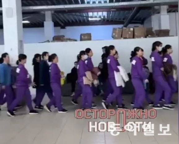 북한 여성 근로자들이 지난해 4월 보라색 유니폼을 입고 러시아 최대 전자상거래 업체 ‘와일드베리스’ 모스크바 창고에서 어디론가 이동하고 있다. 텔레그램 캡처