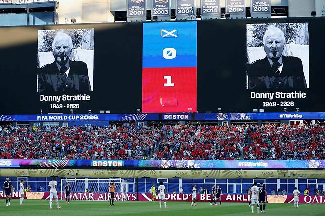 The image of Scottish fan Donny Strathie, who died on June 14 in Boston, is porjected on a big screen during the 2026 World Cup Group C football match between Scotland and Morocco at the Boston Stadium in Foxborough on June 19, 2026. (Photo by FRANCK FIFE / AFP) <저작권자(c) 연합뉴스, 무단 전재-재배포, AI 학습 및 활용 금지>