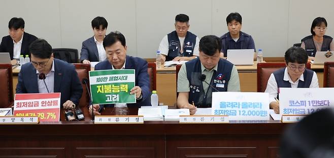 23일 정부세종청사 최저임금위원회에서 내년도 최저임금 인상률을 본격 논의하기 위한 제8차 전원회의가 열리고 있다. 사용자위원인 양옥석 중소기업중앙회 인력정책본부장(왼쪽부터)과 류기정 한국경영자총협회(경총) 전무, 근로자위원인 류기섭 한국노총 사무총장과 민주노총 이미선 부위원장이 상반된 피켓을 세워놓고 있다. 연합뉴스