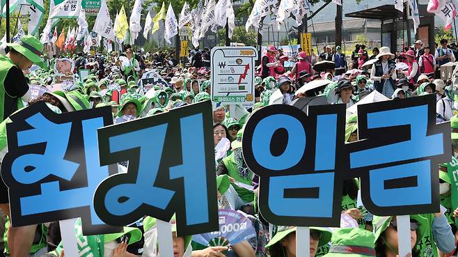 27일 서울 종로구 열린송현녹지광장 앞에서 열린 민주노총 최저임금 인상 결의대회에서 참석자들이 손피켓을 들고 있다. /연합뉴스