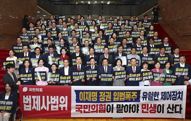 정점식(앞줄 가운데) 국민의힘 원내대표를 비롯한 의원들이 29일 오후 서울 여의도 국회 로텐더홀에서 국회 원 구성 관련 강행 추진을 규탄하는 손 피켓을 들고 구호를 외치고 있다. 뉴시스