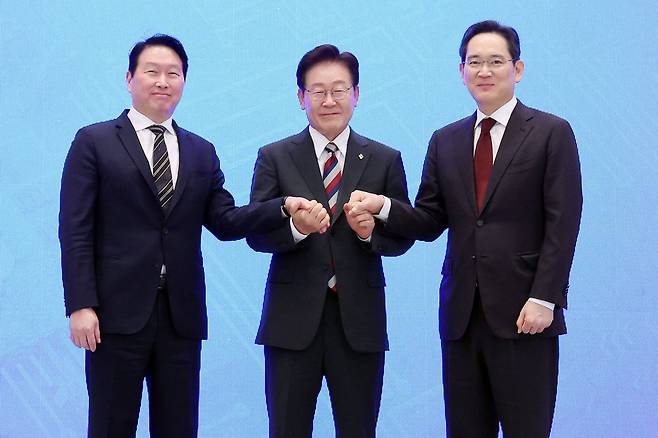 이재명 대통령(가운데)과 이재용 삼성전자 회장(오른쪽), 최태원 SK 회장이 6월 29일 청와대 영빈관에서 열린 ‘대한민국 대도약 3대 메가프로젝트 국민보고회’에서 손을 맞잡고 있다. 뉴시스