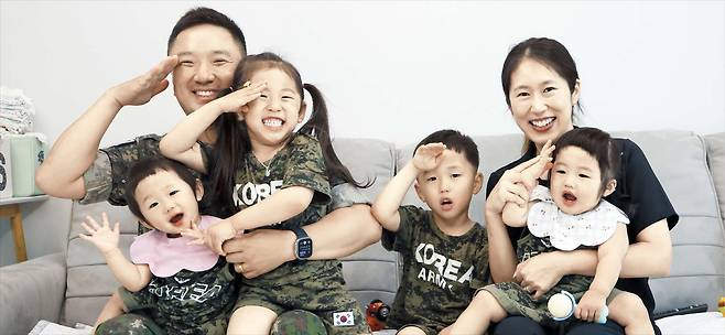 탁은경·김기호 부부의 네 아이가 활짝 웃으면서 군인인 아빠 김씨를 따라 경례 동작을 취하고 있는 모습. 왼쪽부터 세미·연아·연우·세리다. 부부는 “아이들이 주는 행복이 너무 커, 주변에 결혼도 꼭 하고 아이도 꼭 두 명 이상 낳으라고 말한다”고 했다. /고운호 기자