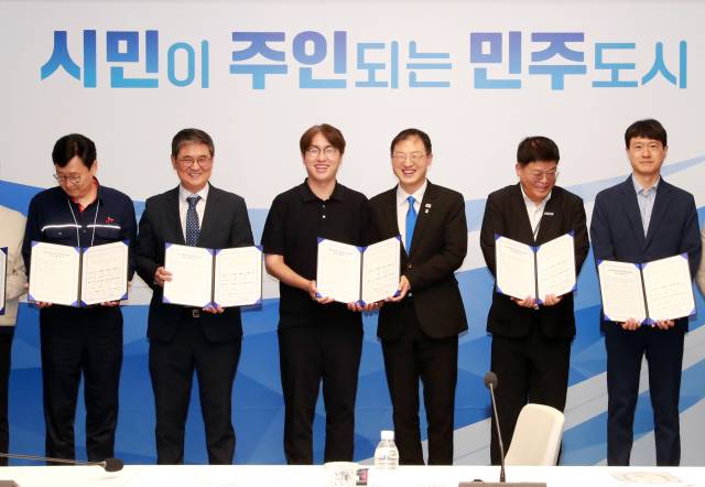 김상욱 울산시장이 9일 시청 대회의실에서 열린 ‘산업 AX 확산 업무협약식’에서 하정우 전 대통령비서실 AI미래기획수석 등 참석자들과 협약서를 들어 보이고 있다. 이날 울산시는 현대자동차, HD현대중공업, SK에너지, 네이버클라우드 등 13개 기업·대학·연구기관과 협약을 맺고 ‘울산산업 AX 협의체’를 출범했다. 울산시 제공