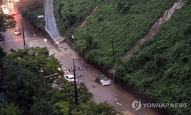 폭포처럼 흘러내린 토사에 차량 피해 (대전=연합뉴스) 이주형 기자 = 폭우가 내린 9일 대전시 유성구 송강동의 한 아파트 단지 옆 야산에서 빗물과 토사가 흘러내리고 있다. 인근 도로에 주차됐던 차량이 토사에 덮이거나 침수 피해를 겪기도 했다. 2026.7.9 coolee@yna.co.kr