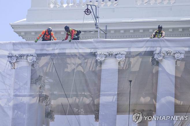 백악관의 기둥 보수 공사 (EPA=연합뉴스) 작업 인부들이 9일(현지시간) 미국 워싱턴DC 백악관 북측 현관 기둥 주변에 세워진 비계에 시각적 착시 효과를 내는 가림막을 설치하고 있다. 2026.7.9