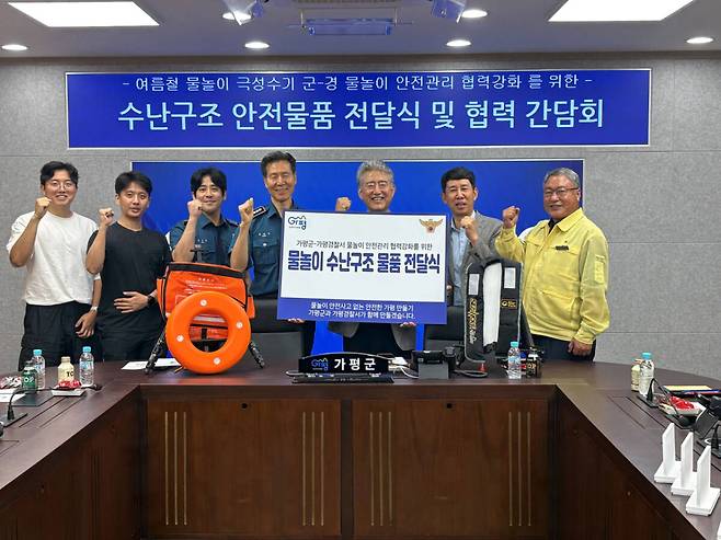 지난 14일 가평군과 가평경찰서 관계자들이 물놀이 수난구조물품 전달식을 마친 뒤 기념촬영을 하고 있다. 가평군 제공