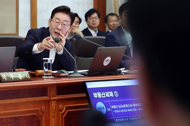 이재명 대통령이 14일 청와대에서 열린 국무회의에서 임기근 국무조정실장에게 실시간 국민 의견을 물어보고 있다. 뉴시스