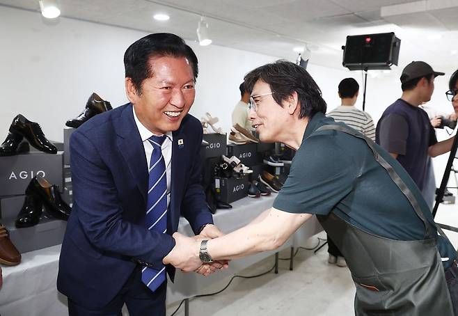 정청래 전 더불어민주당 대표가 4월 24일 오후 서울 성동구 언더스탠드에비뉴에 마련된 청각장애인 수제화 브랜드 '아지오' 매장 오픈 행사에 참석해 유시민 작가와 인사하고 있다. 뉴스1