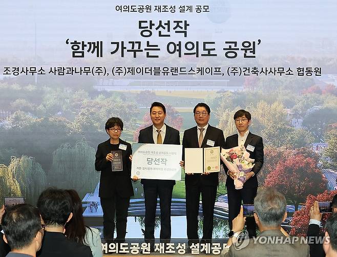 여의도 공원 재조성 설계공모 시상하는 오세훈 서울시장 (서울=연합뉴스) 최재구 기자 = 오세훈 서울시장이 21일 서울시청에서 열린 여의도공원 재조성 설계 공모 시상식에서 당선작인 '함께 가꾸는 여의도 공원'을 출품한 조경사무소 사람과나무, 제이더블유랜드스케이프, 건축사무소 협동원 관계자들과 기념사진을 촬영하고 있다. 2026.7.21 jjaeck9@yna.co.kr