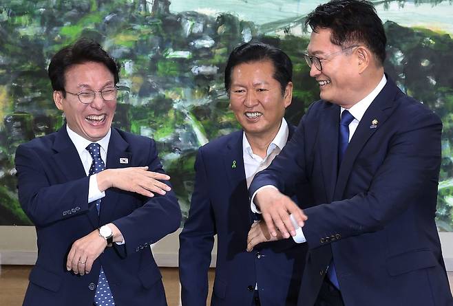 더불어민주당 당권에 도전하는 김민석(왼쪽부터)·정청래·송영길 후보가 21일 서울 중구 서울시의회에서 열린 당대표 후보자 초청 간담회에 앞서 기념촬영을 마친 후 환한 얼굴로 대화하고 있다. 뉴스1