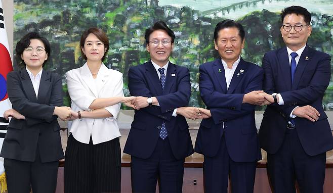 더불어민주당 당권에 도전하는 김보미(왼쪽부터)·고민정·김민석·정청래·송영길 후보가 21일 서울 중구 서울시의회에서 열린 당대표 후보자 초청 간담회에 앞서 손을 맞잡은 채 기념촬영을 하고 있다. 뉴스1