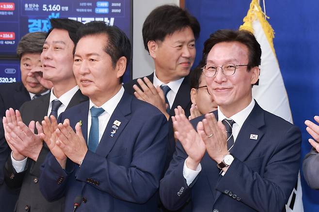 정청래·김민석 더불어민주당 대표 후보가 7월20일 국회에서 열린 민주당 공명선거 실천 서약식에 참석해 기념 촬영을 마치고 손뼉 치고 있다. ⓒ연합뉴스