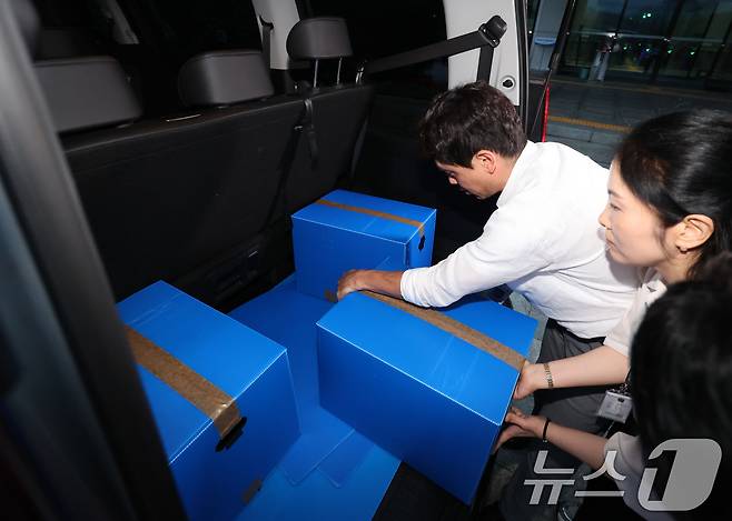 6·3 지방선거 투표용지 부족 사태를 수사 중인 검·경 합동수사본부 관계자들이 23일 오후 경기 과천시 중앙선거관리위원회에 대한 압수수색을 마친뒤 압수상자를 차량에 싣고 있다. 이날 검·경 합동수사본부는 선거관리위원회 관계자들의 투표율 통계 조작 정황을 포착해 중앙선관위와 경기도선관위 등에 대한 압수수색에 나섰다.(공동취재) 2026.7.23 ⓒ 뉴스1 이광호 기자