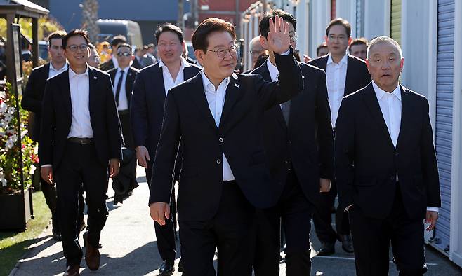 이재명 대통령이 24일(현지 시간) 미국 샌프란시스코 더 램프 레스토랑에서 열린 글로벌 AI 리더 만찬에 참석하며 손 인사를 하고 있다. 뉴시스