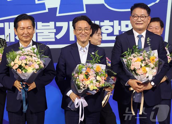 더불어민주당 본경선 후보로 진출한 정청래(왼쪽부터), 김민석, 송영길 후보가 23일 오후 서울 여의도 국회 의원회관에서 열린 당대표·최고위원 선출을 위한 예비경선 결과발표 뒤 단상에 올라 기념촬영을 하고 있다. 2026.7.23 ⓒ 뉴스1 황기선 기자