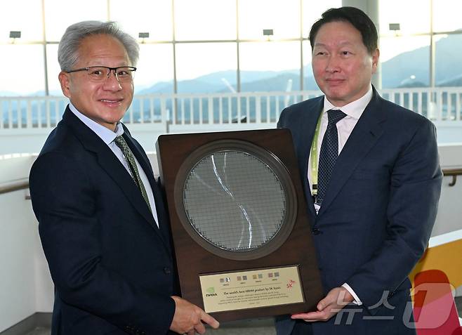젠슨 황 엔비디아 CEO가 31일 경북 경주시 경주예술의전당에서 열린 아시아태평양경제협력체(APEC) CEO 서밋에 참석해 최태원 SK그룹 회장 겸 대한상의 회장으로 부터 SK하이닉스의 HBM4 반도체 웨이퍼를 선물로 받고 있다. (공동취재) 2025.10.31 ⓒ 뉴스1 김민지 기자
