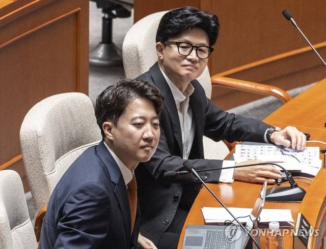 이준석 개혁신당 대표(앞)와 한동훈 무소속 의원이 지난 24일 국회에서 열린 예산결산위원회 전체 회의에 참석해 동료 의원들의 인사말을 듣고 있다. 연합뉴스