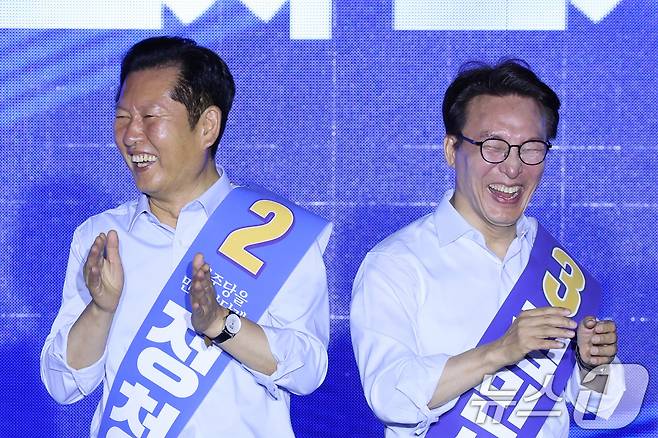 더불어민주당 당권 주자인 정청래(왼쪽), 김민석 의원이 2일 부산 벡스코에서 열린 당대표·최고위원 합동연설회에서 미소짓고 있다. 2026.8.2 ⓒ 뉴스1 신웅수 기자