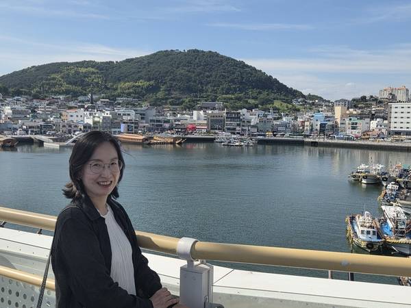 김정련 통영교방 대표가 <통영의 맥> 공연 무대인 강구안을 배경으로 사진을 찍고 있다. 현대 건축물 뒤로 세병관이 보인다. /표세호 기자
