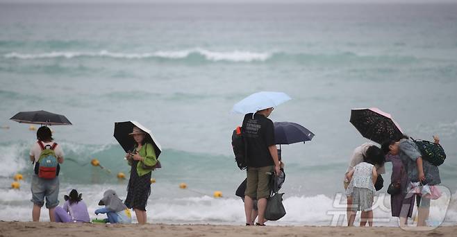 제주도 해상에 풍랑주의보가 내려지고, 비가 내리는 9일 오전 제주시 조천읍 함덕해수욕장에서 우산을 쓴 관광객들이 파도가 이는 바다를 바라보고 있다. 2026.8.9 ⓒ 뉴스1 강승남 기자